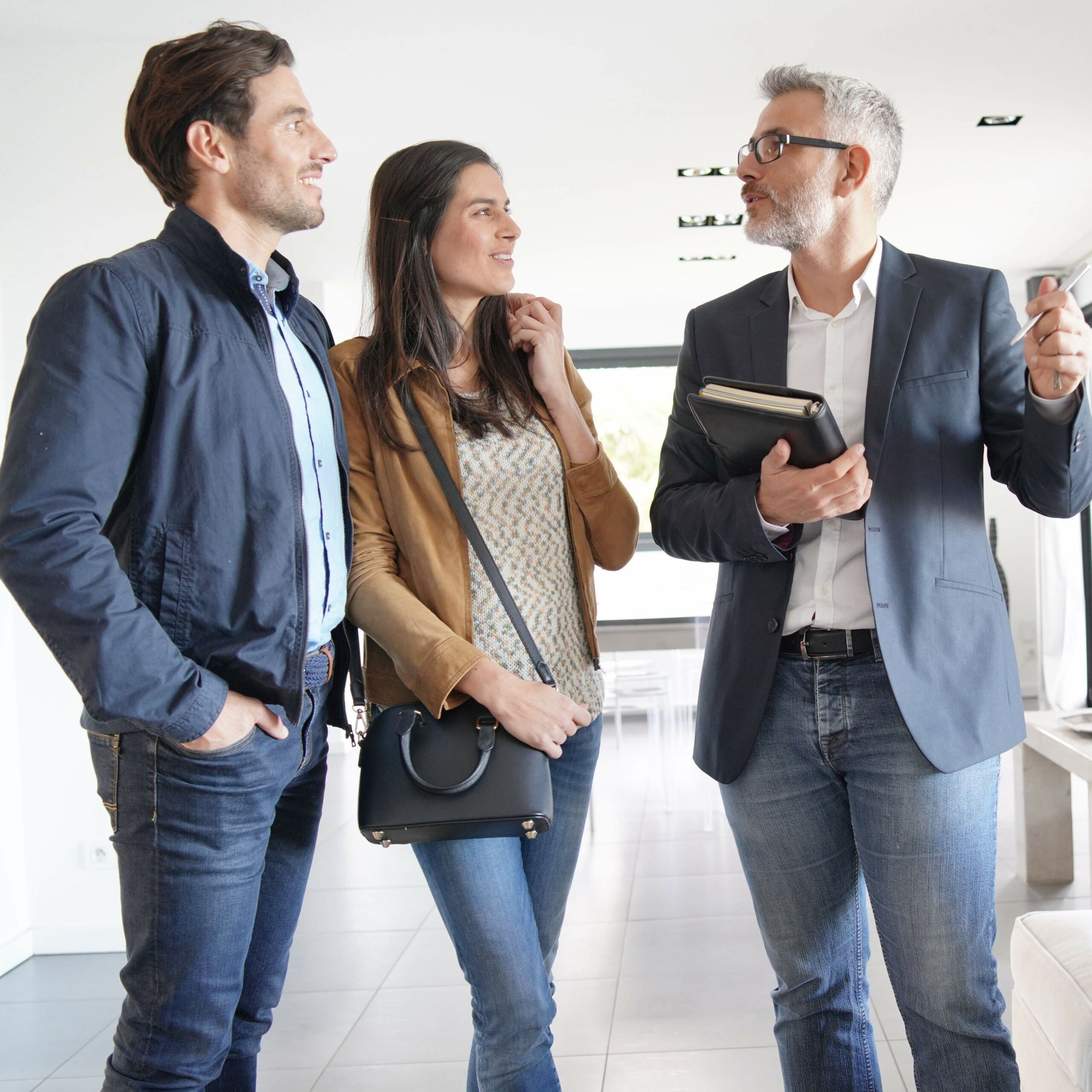 couple-with-real-estate-agent-visiting-modern-house