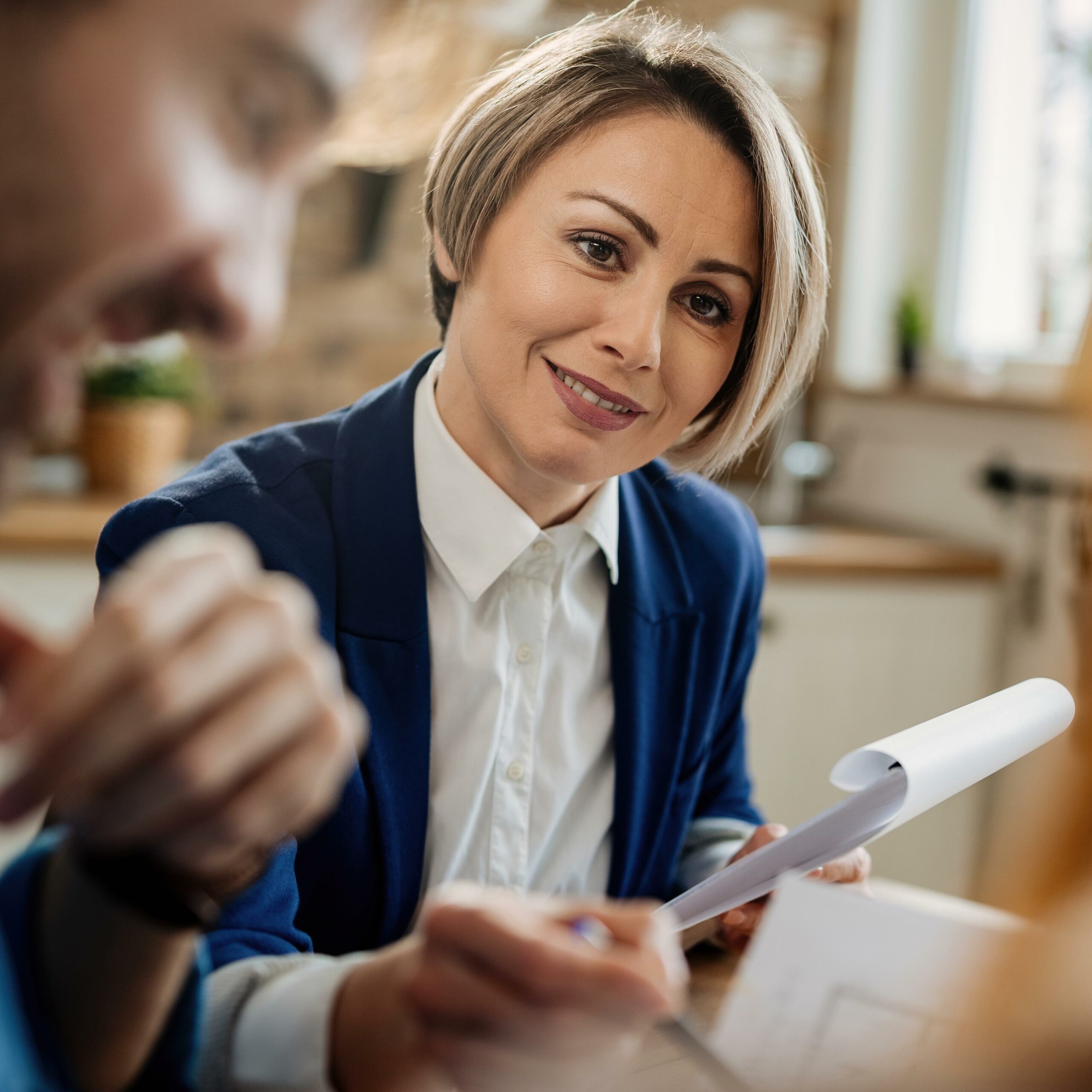Smiling financial advisor talking to her clients during a meeting.